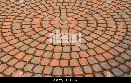 Red circular paved bricks with dirty moss and worn age Stock Photo