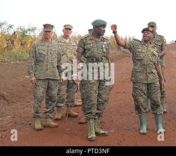 Maj. General Wilson Mbadi, the Deputy Chief of Uganda People’s Defense Force (far right), gives Combined Joint Task Force-Horn of Africa commander U.S. Marine Corps Brig. Gen David Furness (far left) a tour of the Uganda Rapid Deployment Capability Center training location, based in Jinja, Uganda, July 7. The tour took place on the same day as an historic graduation of 60 UPDF engineers from Class 17.2, which marked the conclusion of the first class where UPDF instructors both ran and taught the entire course. Class 17.2’s training took place at the Uganda Rapid Deployment Capability Center. Stock Photo