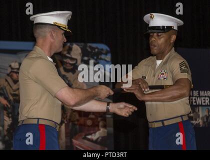 Sergeant Major Cortez L. Brown, right, receives the Noncommissioned Officer Sword from Col Jeffery C. Smitherman, commanding officer of 6th Marine Corps District (6MCD), during the 6MCD Relief and Appointment Ceremony at the base theater aboard Marine Corps Recruit Depot (MCRD) Parris Island, South Carolina, July 7, 2017. Sergeant Major Anthony N. Page was relieved by SgtMaj Cortez L. Brown after serving as the sergeant major of 6MCD for more than 3 years. Stock Photo