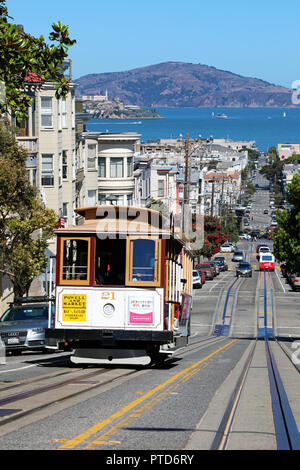 Street scene with a Cable Car tram and Alcatraz Prison island in San Franciso, California, USA Stock Photo