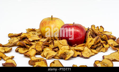 Cropped and close-up view of two apples, one yellow and the other red, surrounded by many slices of dehydrated apple slices Stock Photo