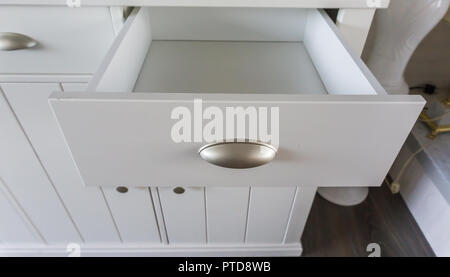 Empty open modern white wooden drawer with nothing inside so empty space to put whatever you like Stock Photo