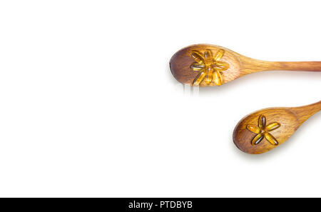 Wooden spoons with fish oil capsules on white, isolated Stock Photo