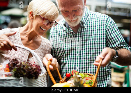 Portrait of beautiful elderly couple in market buing food Stock Photo