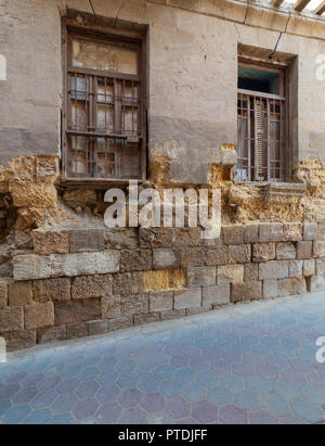 Angled view of two adjacent broken windows and grunge stone bricks wall in abandoned Darb El Labana district, Cairo, Egypt Stock Photo