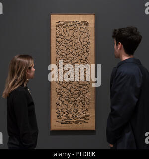 London, UK.  9 October 2018. Visitors view 'Epitaph', 1968, by Anni Albers.  Preview of the UK's first exhibition of works by German artist Anni Albers at Tate Modern who used the ancient art of hand-weaving to produce works of modern art.  Over 350 of her artworks from major collections from Europe and the US are on show 11 October to 27 January 2019.  Credit: Stephen Chung / Alamy Live News Stock Photo
