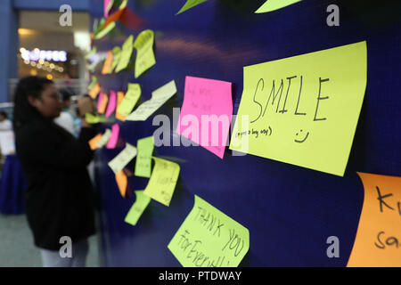 Pasay City, Philippines. 9th Oct, 2018. A woman writes a note on a freedom wall during a celebration of World Mental Health Day in Pasay City, the Philippines, Oct. 9, 2018. World Mental Health Day is celebrated on Oct. 10 every year to raise awareness on mental health issues around the world. Credit: Rouelle Umali/Xinhua/Alamy Live News Stock Photo