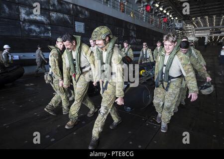 CORAL SEA (July 17, 2017) Soldiers, assigned to 2nd Battalion, The Royal Australian Regiment, carry a combat rubber raiding craft in the well deck of the amphibious transport dock USS Green Bay (LPD 20) as a part of a joint amphibious assault raid exercise during Talisman Saber 17. Talisman Saber is a biennial U.S.-Australia bilateral exercise held off the coast of Australia meant to achieve interoperability and strengthen the U.S.-Australia alliance. Stock Photo