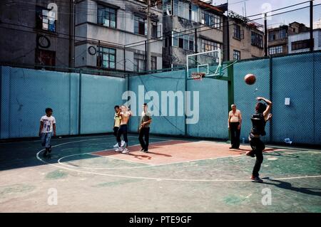 Beijing / China - JUN 24 2011: people playing basketball on the open street field in a residential area Stock Photo