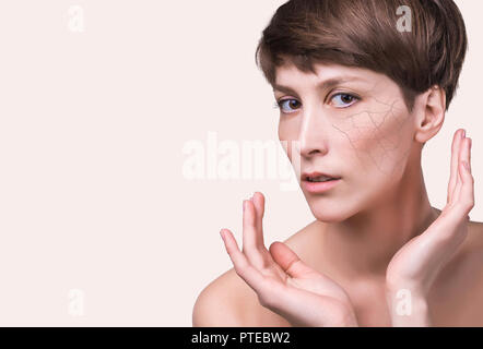 Woman face covered with cracked earth texture- symbol of dry skin Stock Photo