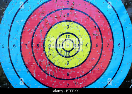 Archery target close up with many arrow holes in gold red blue and black Stock Photo