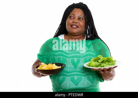 Thoughtful happy fat black African woman smiling while holding b Stock Photo