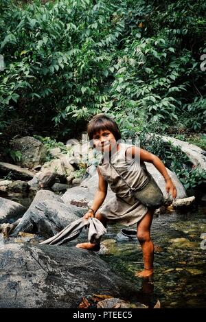 Santa Marta, Magdalena / Colombia - MARCH 10 2016 : kogi tribal kid doing laundry in the nearby stream close to their home Stock Photo