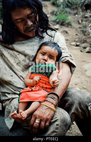 Santa Marta, Magdalena / Colombia - MARCH 10 2016 : kogi tribal member man with his new born son in front of their cloudforest home Stock Photo