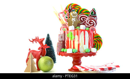 On trend festive candyland Christmas drip cake on white background. Stock Photo