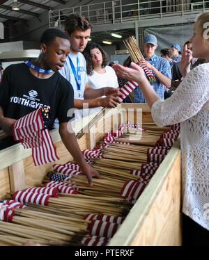 Victor Oluwagbemi, Joint Base McGuire-Dix-Lakehurst, New Jersey, Youth of the Year; and Air Force Teen Council members Andrew Smith, Jamie Butikofer and Dawson Gildig place flags in a storage. Each year during the Air Force Youth of the Year and Teen Council Summit, participants perform community service. This year, they rolled flags that had been displayed over Memorial Day weekend at the Fort Sam Houston National Cemetery on Joint Base San Antonio, Texas. In just a few hours on July 12, 2017, they rolled and stored 35,000 flags. Stock Photo