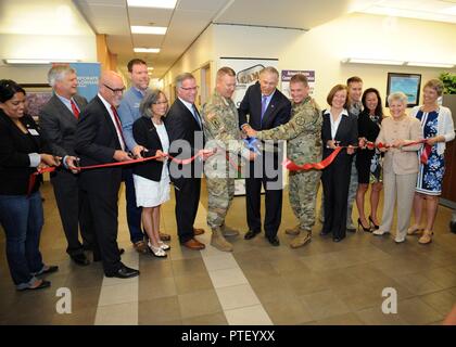 Maj. Gen. Mark Stammer, I Corps Deputy Commanding General (center-left) with Washington Governor Jay Inslee (center) and Col. Dan Morgan, Joint Base Garrison Commander (center-right), team up on the big scissors while other local, state and national leaders join in for the ribbon cutting of the WorkSource/American Job Center at the Joint Base Lewis-McChord Hawk Transition Center, July 7, 2017. Stock Photo