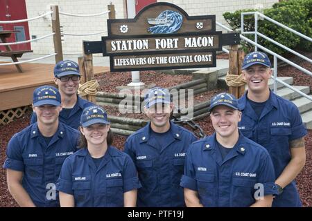 Petty Officer 3rd Class Michael Sparks (left to right), Fireman Samuel Ragsdale, Fireman Jordan Markland, Petty Officer 2nd Class Tyler McGregor, Petty Officer 2nd Class Zane Hutson and Seaman Crewe Goralski reunite at Station Fort Macon, North Carolina, July 10, 2017. Sparks and Ragsdale were rescued by the others July 6 after a diving incident where the two were stranded eight miles off Atlantic Beach. Stock Photo