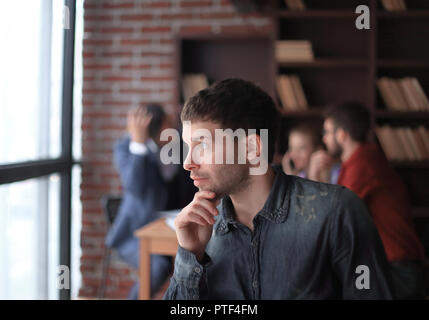 pensive young designer looking out the office window. Stock Photo