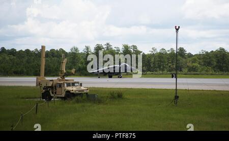 An AV-8B Harrier II lands on the runway next to the Air Traffic Navigation, Integration, and Coordination System at Marine Corps Air Station Cherry Point, N.C., July 19, 2017. The aircraft was tracked by the ATNAVICS before communication was transferred to Marines manning the air traffic control tower aboard the air station.  The Harrier is from Marine Attack Squadron 231, Marine Aircraft Group 14, 2nd Marine Aircraft Wing and MACS-2 is assigned to Marine Air Control Group 28, 2nd MAW. Stock Photo