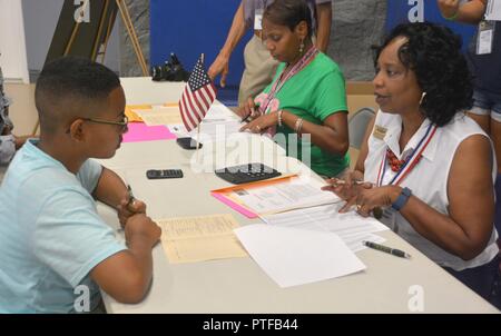 Christine Murphy, a financial counselor at Army Community Service Survivor Outreach Service, acts as 'Uncle Sam' and explains to Ishmel Miller, a Fort Lee dependent and Youth Center patron, how much taxes he would owe the federal government with his scenario during the Child and Youth Services Reality Store Friday at the Youth Center. The event is a 4-H Virginia Cooperative Extension program that allowed the teens to simulate paying bills and making financial decision based on a career and family scenario. Stock Photo