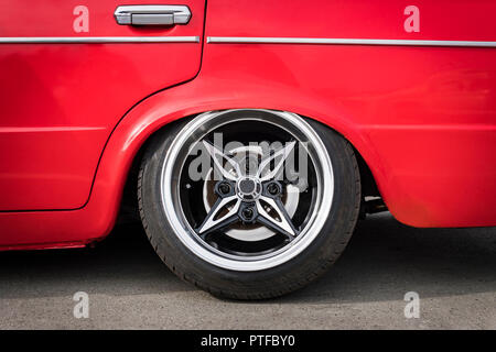 Front of the car to adjust the lower suspension to the ground. Side view on new luxury car wheel on silver metal rim with black shine tire. Luxury spo Stock Photo