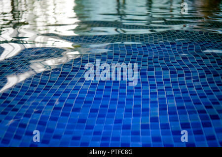The azur mosaic bottom of an aquapark pool. A view to the tiled floor through the clean water of indoor pool. Ripples and blinks on water surface of i Stock Photo