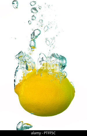 A single lemon splashing into water with air bubbles Stock Photo