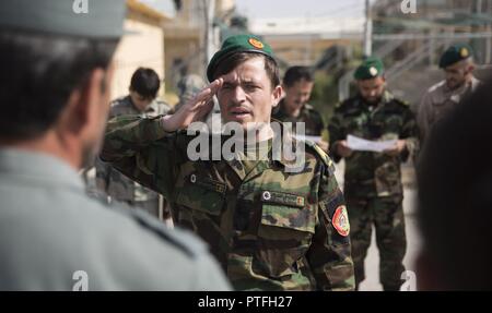 An Afghan National Army soldier steps up to receive his certificate for graduating a map reading class at Bost Airfield, Afghanistan, July 22, 2017. With assistance from U.S. Marine advisors with Task Force Southwest, the three-week course covered multiple areas including measuring straight and curved line distances, as well as being able to plot and pull a six-digit grid from a map. Stock Photo