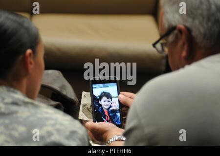 Sgt. Angela Myers, 311th ESC ammunition sergeant, and her Uncle Corey Rose, chat with her son, Zander, on Facetime. This is Myers and her son's first time meeting their uncle and great uncle or any biological family. Myers was raised in foster care. Stock Photo