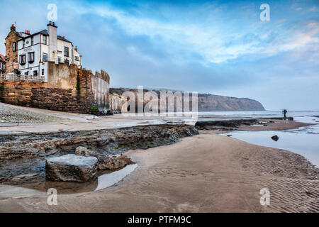 Robin Hood's Bay, North Yorkshire, England, UK, on an overcast winter morning. A photographer is at work, waiting for the light. Stock Photo