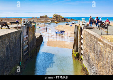 6 July 2018: Bude, Cornwall, UK - The canal and lock gates standing open to the sea, as people relax in the continuing heatwave. Stock Photo