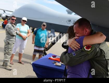 Maj. Richard, 432nd Wing MQ-1 Predator pilot, hugs his cousin July 15, 2017, at the Lethbridge International Airshow in Alberta, Canada. Richard grew up with his cousin in Lethbridge for 15 years hasn't seen her since moving to the United States. Richard was able to reconnect with family and friends in his hometown while in town showcasing the MQ-9 Reaper and its capabilities.