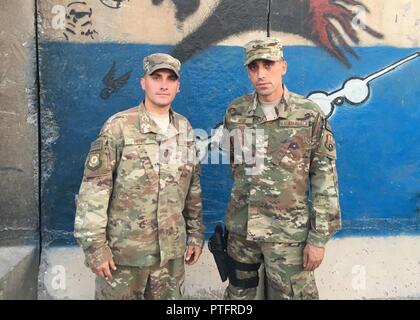 U.S. Air Force Master Sgts. Daniel and Scott Hose, both assigned to the 370th Air Expeditionary Advisory Group, pose for a photo at Qayyarah West Airfield, Iraq, July 13, 2017. The twin brothers are both deployed to Iraq in support of Combined Joint Task Force -Operation Inherent Resolve. CJTF-OIR is the global Coalition to defeat ISIS in Iraq and Syria. Stock Photo