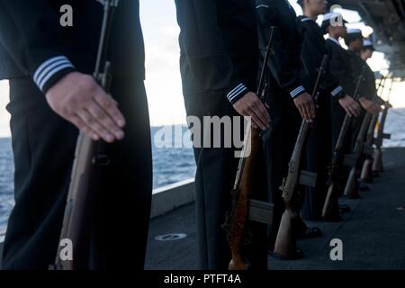 CORAL SEA (July 15, 2017)  The firing detail stands at attention during a burial-at-sea ceremony for Julius “Harry” Frey and his wife, Jerry, aboard the Navy's forward-deployed aircraft carrier, USS Ronald Reagan (CVN 76), during Talisman Saber 2017. Frey, a WWII veteran, served aboard USS Lexington (CV 2) during the Battle of Coral Sea and his ashes were laid to rest at the coordinates where the ship sank. Talisman Saber is a realistic and challenging exercise that brings service members closer and improves both U.S. and Australia's ability to work bilaterally and multilaterally, and prepares Stock Photo