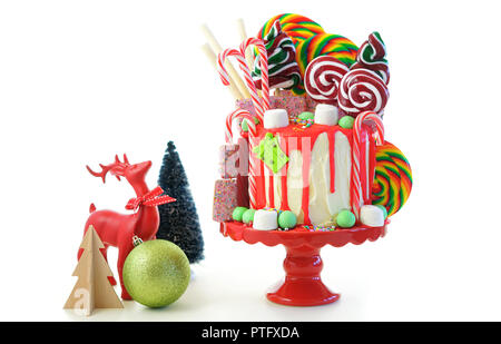 On trend festive candyland Christmas drip cake on white background. Stock Photo