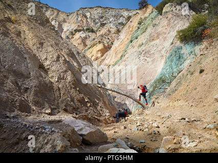 Old man in red shirt and black dog hiking in the mountains. Outdoor travel concept Stock Photo