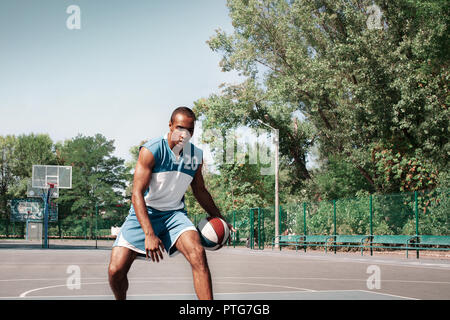 Picture of young confused african basketball player practicing outdoor. Fit afro man in motion and movement. athletic and sport lifestyle concept Stock Photo