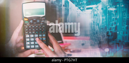 Composite image of cropped hands of businesswoman using calculator Stock Photo