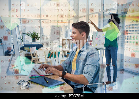 Male executive using computer with colleague in virtual reality headset Stock Photo