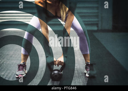 Muscular woman lifting kettlebells Stock Photo