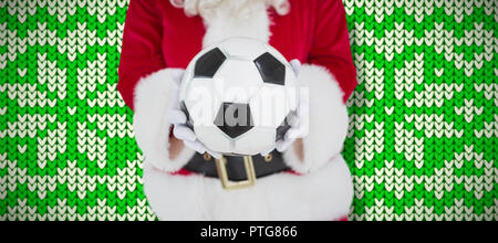 Composite image of mid section of santa holding football Stock Photo