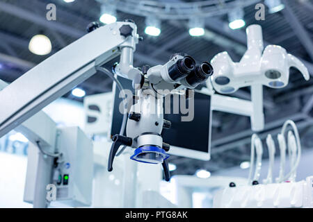 Dental microscope on the background of modern dentistry. Medical equipment. Dental operating microscope with rotary double binocular. Stock Photo