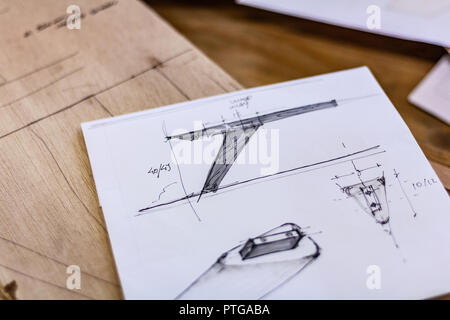 Eco-friendly woodworker's shop. Details and focus on the project sketches, sawdust, and planers or chisels, while making legs for a nut table. Stock Photo