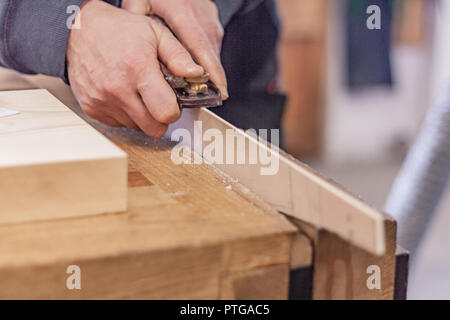 Eco-friendly woodworker's shop. Details and focus on the texture of the material, sawdust, and planers or chisels, while making legs for a nut desk. Stock Photo