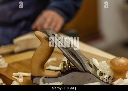 Eco-friendly woodworker's shop. Details and focus on the texture of the material, sawdust, and planers or chisels, while making legs for a nut desk. Stock Photo