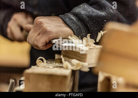 Eco-friendly woodworker's shop. Details and focus on the texture of the material, sawdust, and planers or chisels, while making legs for a nut desk. Stock Photo