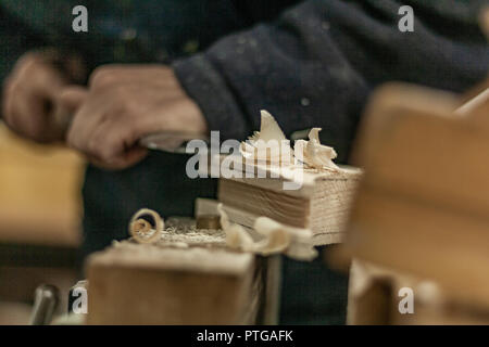 Eco-friendly woodworker's shop. Details and focus on the texture of the material, sawdust, and planers or chisels, while making legs for a nut desk. Stock Photo