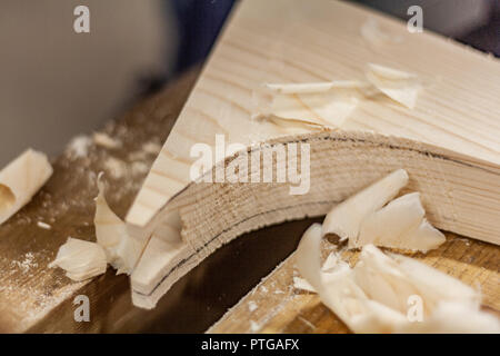 Eco-friendly woodworker's shop. Details and focus on the texture of the material, sawdust, and planers or chisels, while making legs for a nut desk. Stock Photo