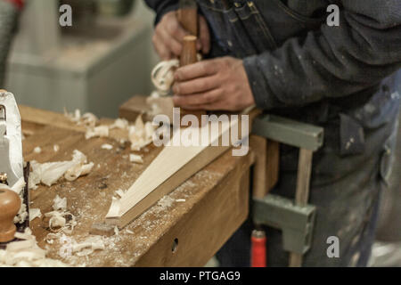 Eco-friendly woodworker's shop. Details and focus on the texture of the material, sawdust, and planers or chisels, while making legs for a nut desk. Stock Photo